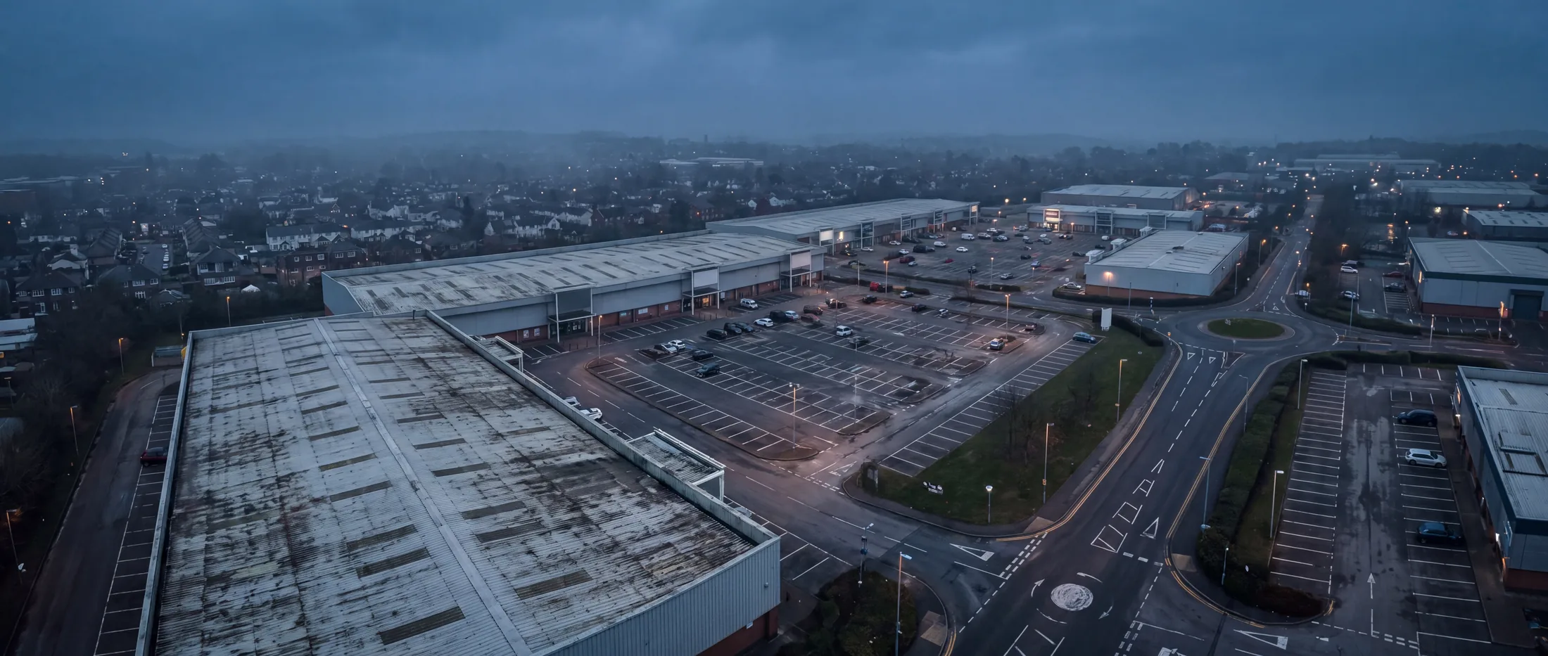Aerial view of a British retail park at dusk.